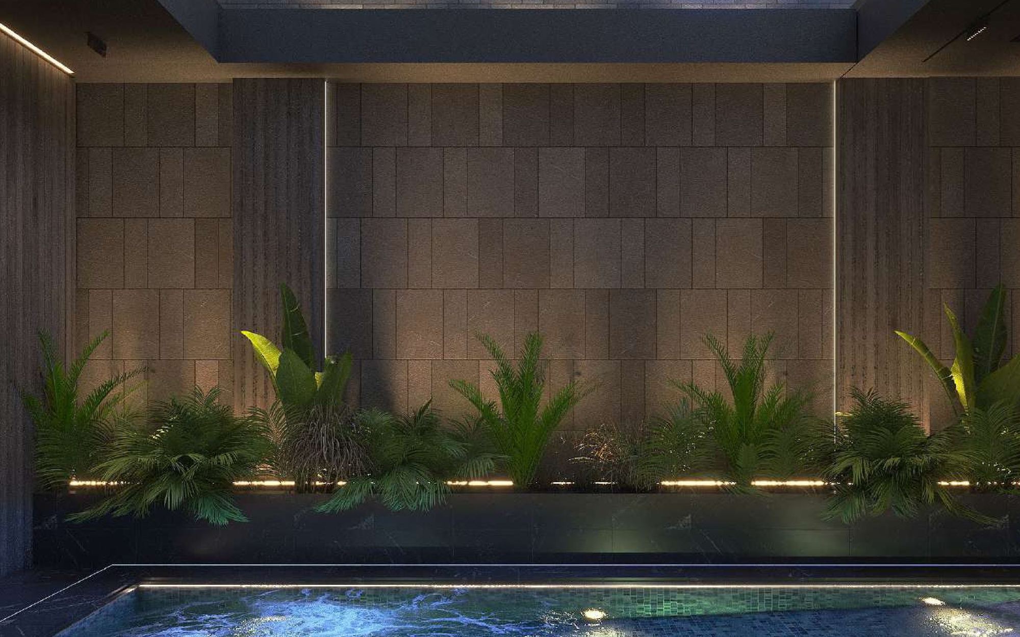 Indoor pool at night with lit planting and stone walls